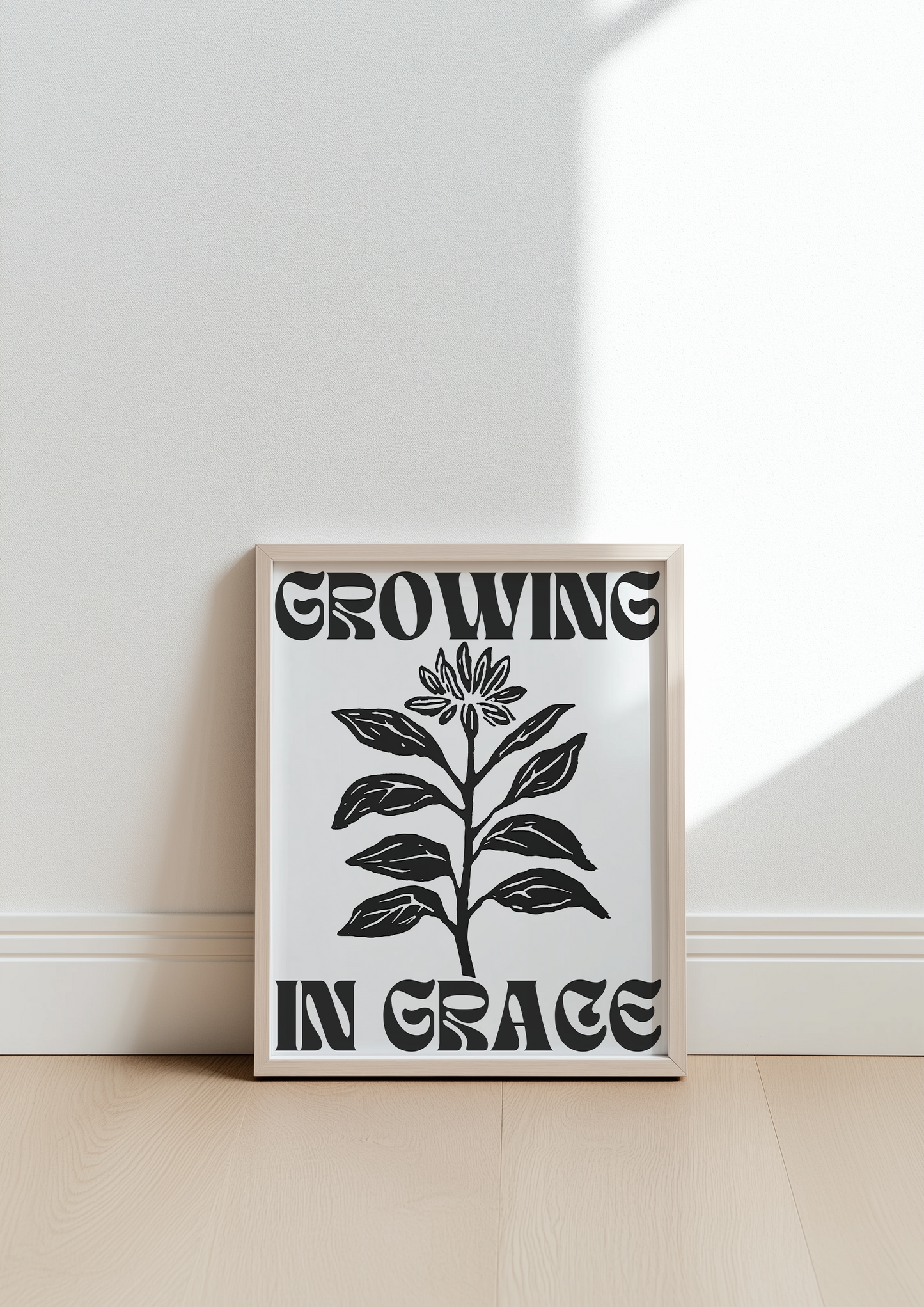 Growing in Grace black and white minimalist Christian wall art print leaning against a wall with natural light ideal for modern home decor