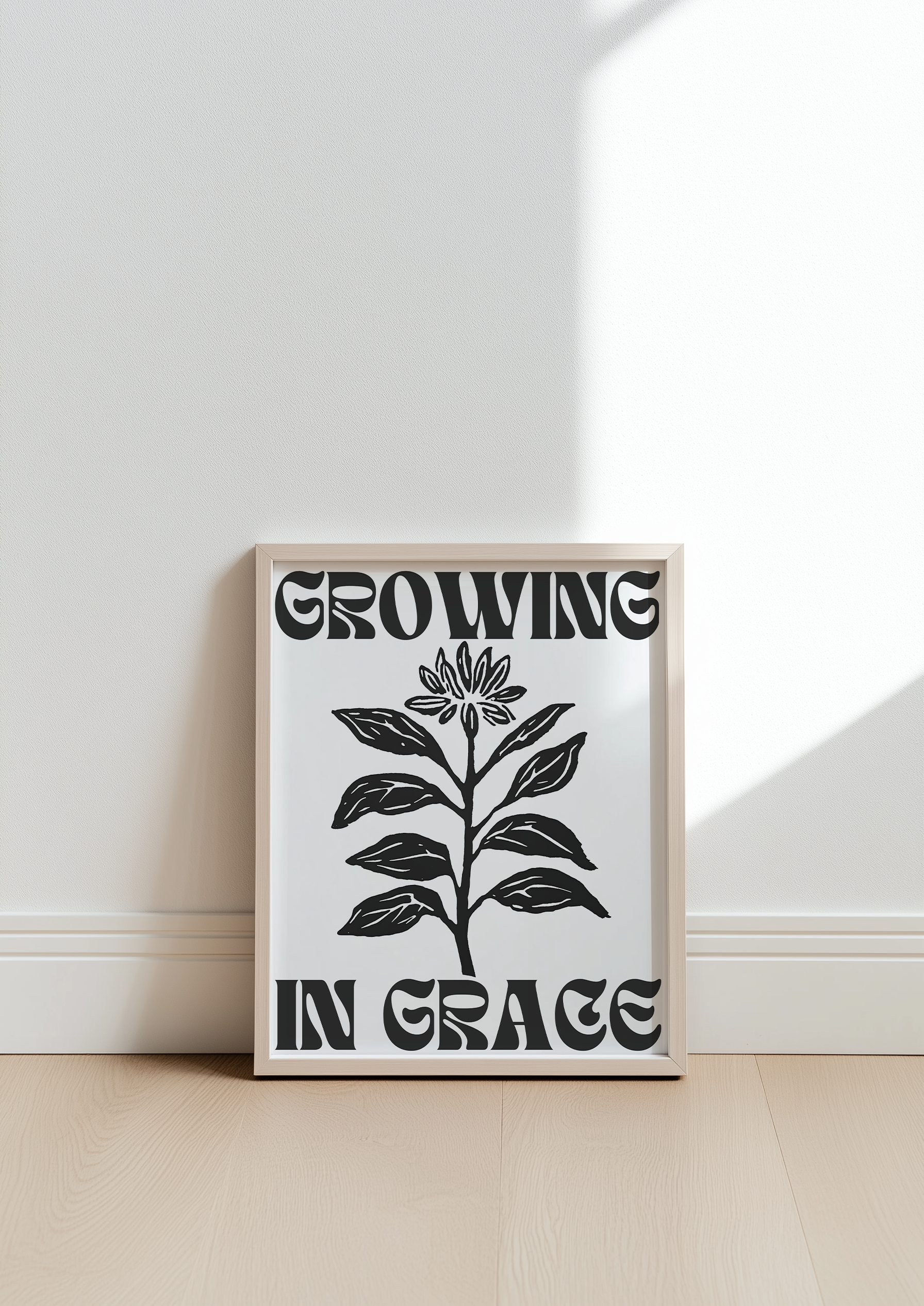 Growing in Grace black and white minimalist Christian wall art print leaning against a wall with natural light ideal for modern home decor
