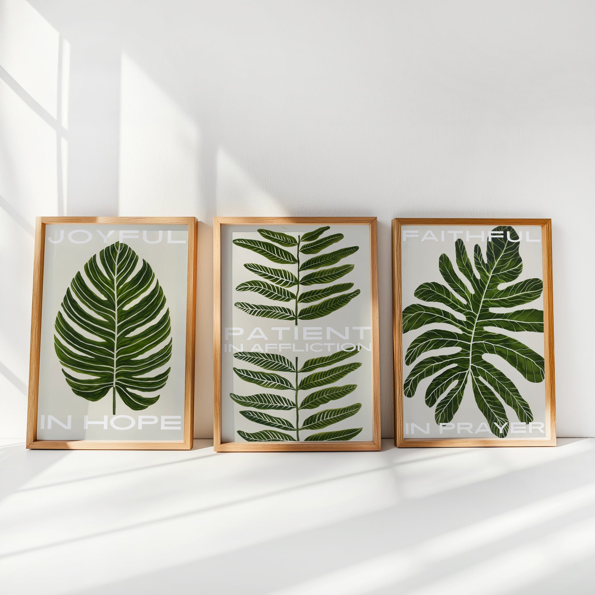 Three-piece Christian wall art set featuring botanical prints with biblical encouragement: 'Joyful in Hope,' 'Patient in Affliction,' and 'Faithful in Prayer.